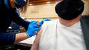 Amber Pedro, a volunteer from Family Practice Laporte, administers the vaccine into the arm of Robert Keen, 84 of Forksville, in the cafeteria of the Sullivan County Elementary School.