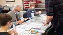 Volunteers open and sort mail-in ballots in Erie while poll watchers observe.