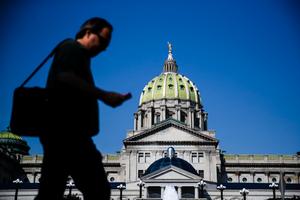 Man walks in front of Pennsylvania state capitol