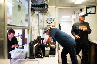 Bob Morris, center, owner of Burgers & More, takes a customer order while working with his brother, Scott Morris, right, at the family burger business in Waynesburg. Morris said he has plans to expand his shop in the summer to also serve ice cream for locals.