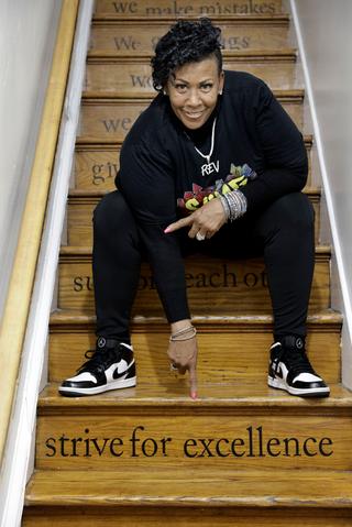 The Rev. Michelle Simmons, founder and executive director of Why Not Prosper, points to one of the inspirational messages on the staircase risers at a Why Not Prosper recovery home in Philadelphia. Her organization received a license for one of its recovery homes, and Simmons plans to seek licenses for its other facilities. 